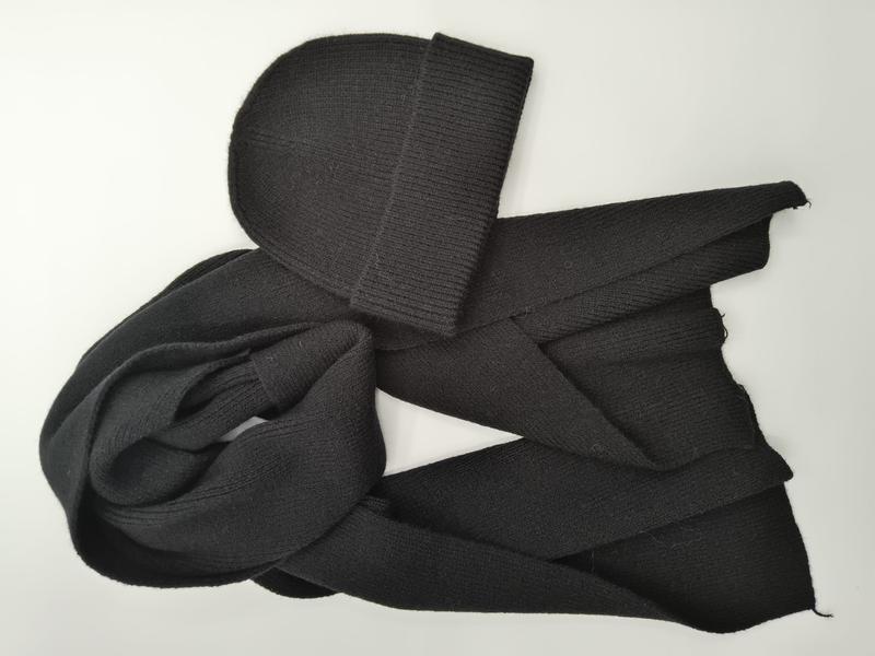Bonnet côtelé noir et longue écharpe en maille stretch noire posés à plat