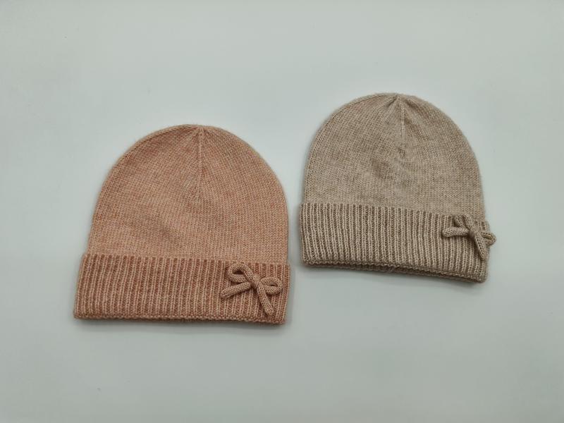 Deux bonnets en maille douce avec nœud décoratif et revers côtelé