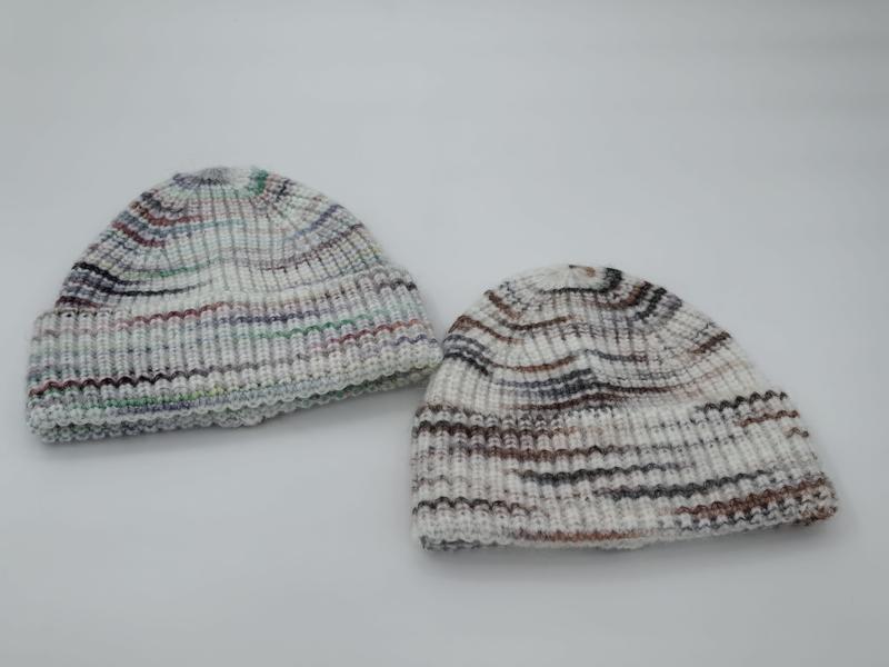 Deux bonnets tricotés côtes blanc rayures multicolores tons chauds et froids – fond blanc