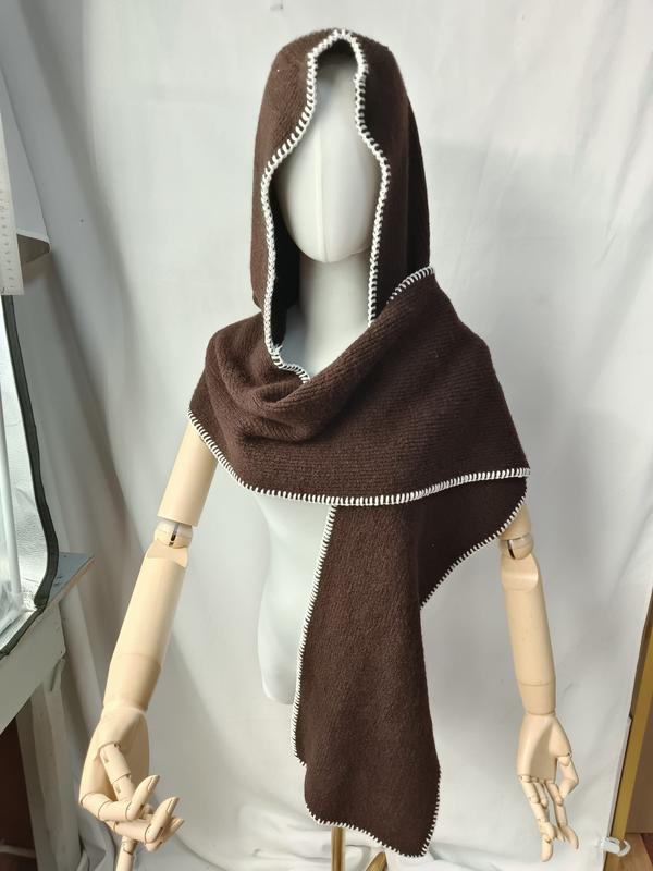 Cape à capuche tricotée marron foncé avec bordure point de surjet blanc sur mannequin bras en bois