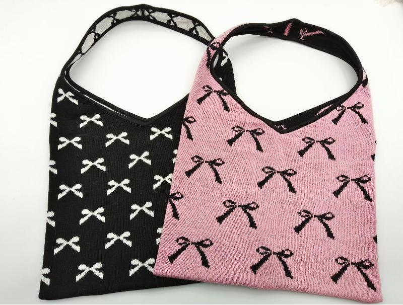 Deux sacs hobo en maille jacquard motif nœuds : un noir à nœuds blancs