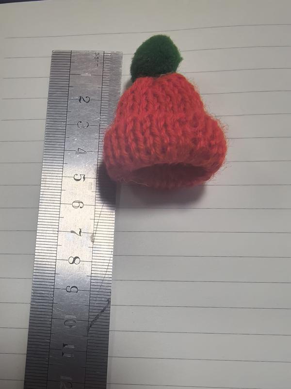 Minuscule bonnet tricot rouge pompon vert mesuré sur règle environ 4cm – accessoire déco miniature