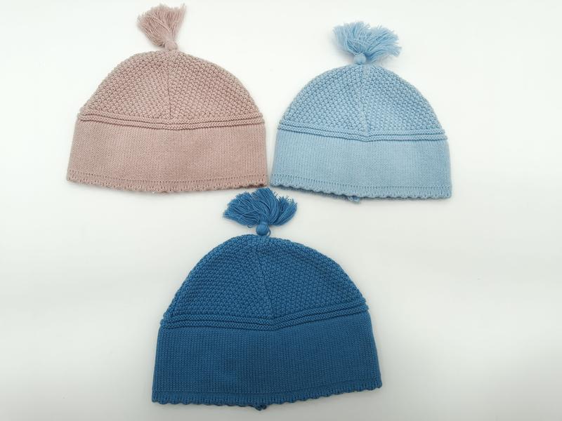 Trois bonnets bébé tricotés à pompon en rose poudré